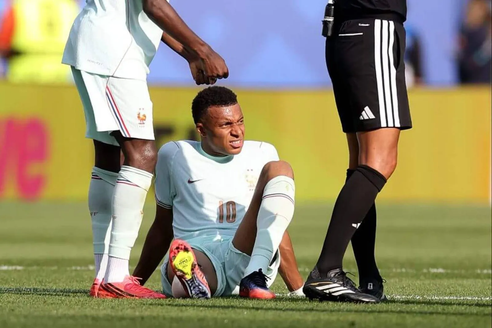 Mbappe sitting on the pitch in apparent discomfort