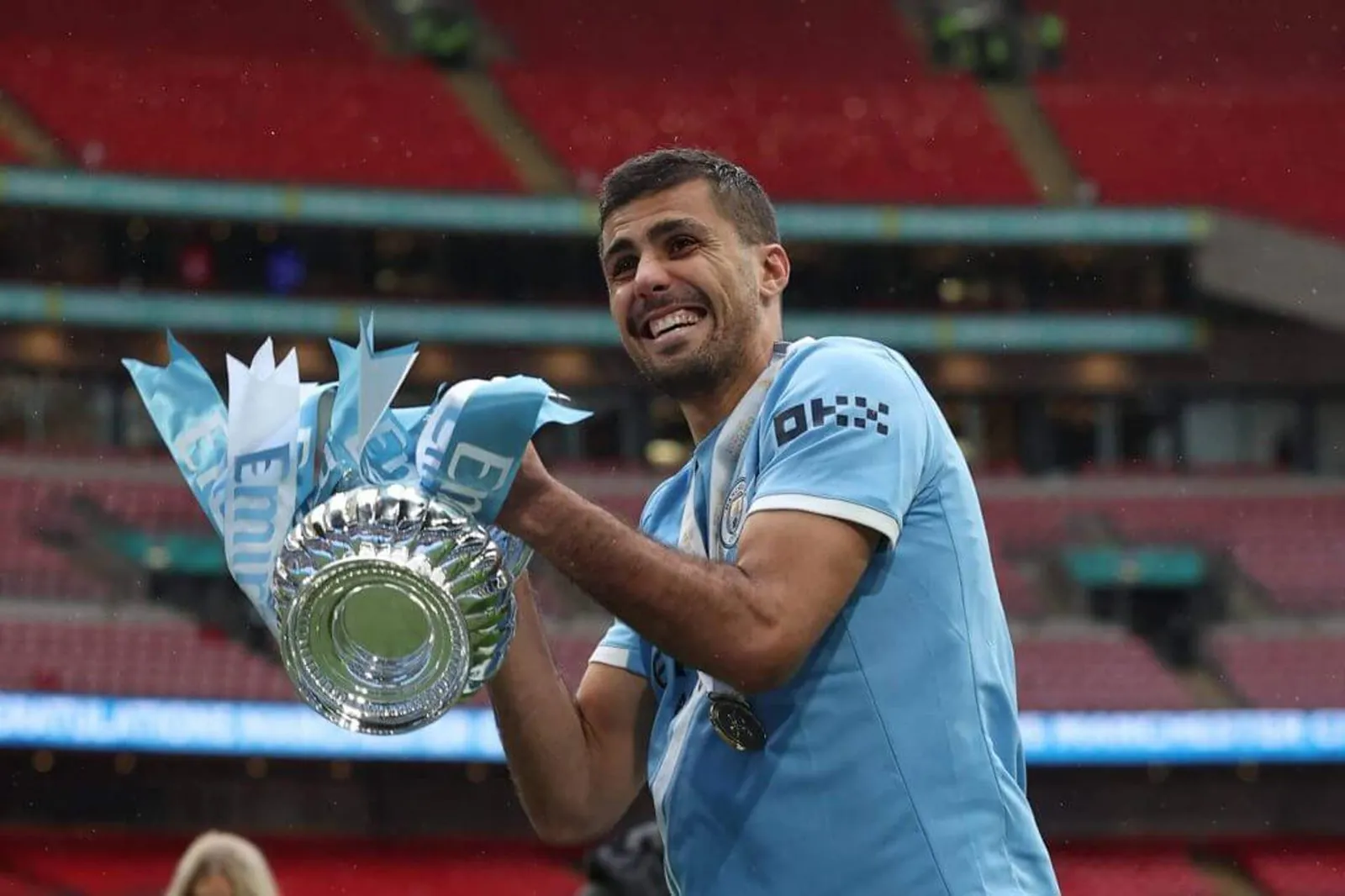 Manchester City's Spanish midfielder Rodri celebrates with the FA Cup trophy on the Wembley pitch