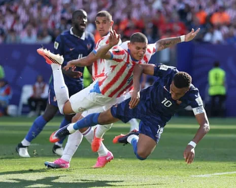 Kylian Mbappe and Juan Jose Caceres compete for the ball mid-air during a World Cup match